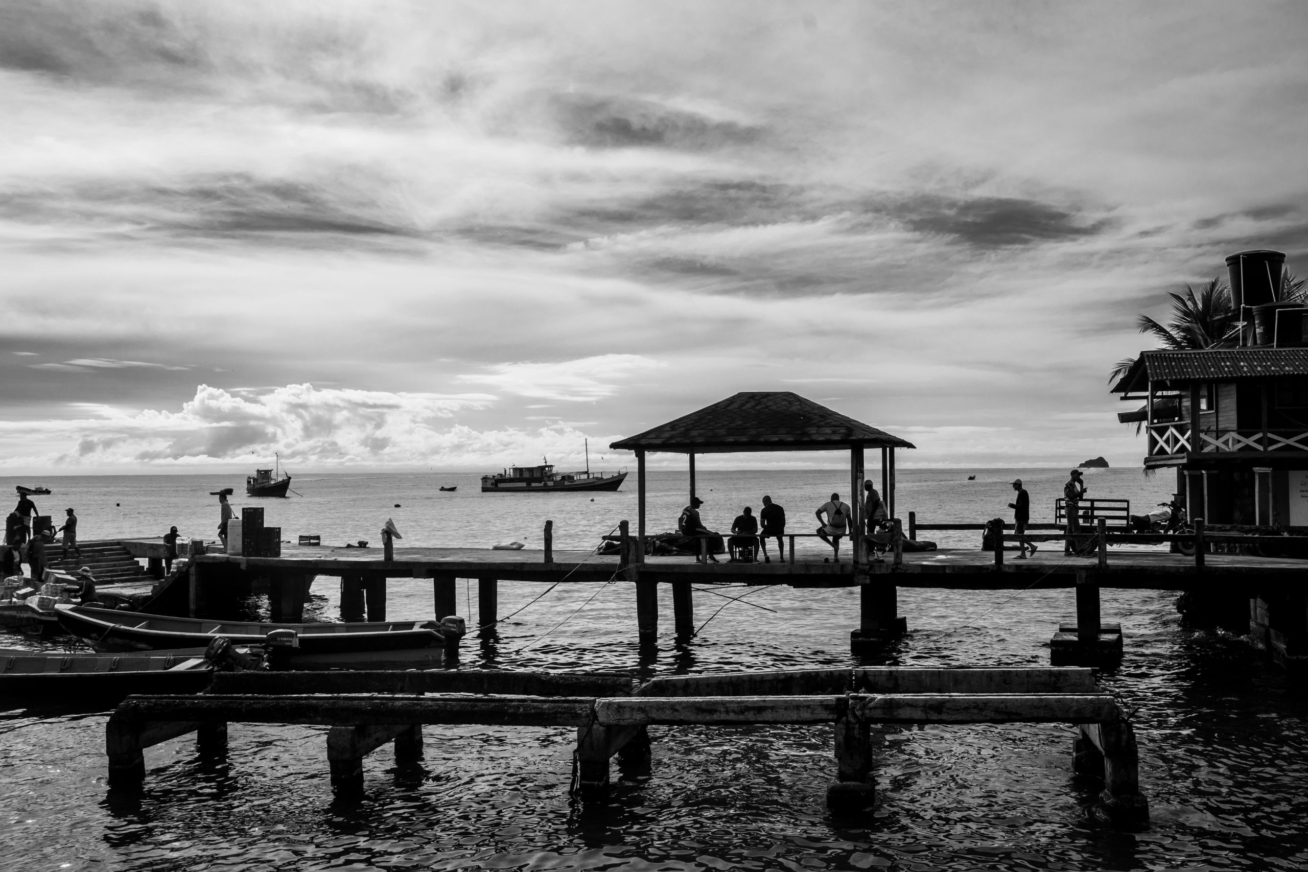 Black and white photo capturing the serene harbor scene at Capurganá, Colombia.